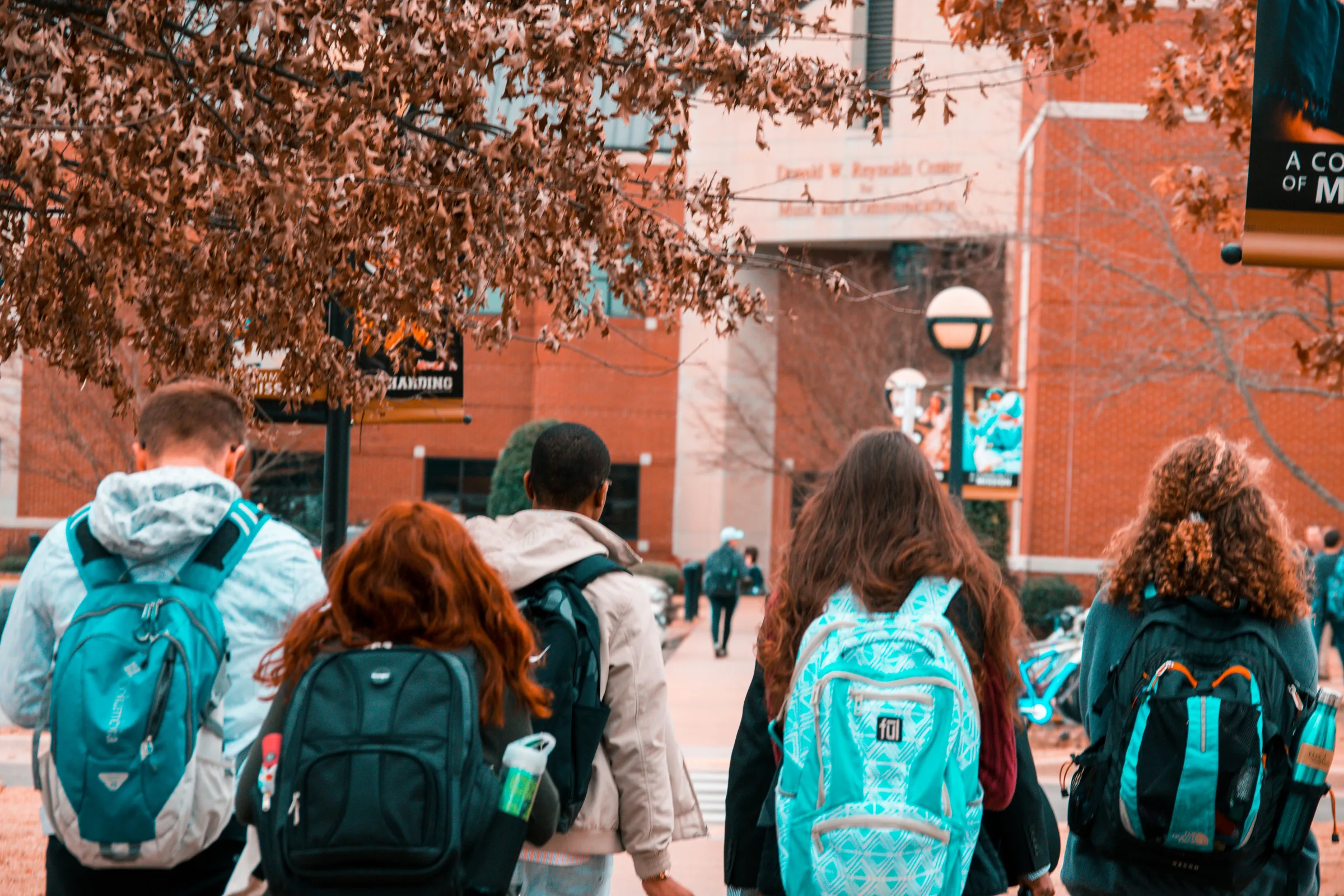 Des étudiants avec leurs sacs à dos marchent vers un campus universitaire