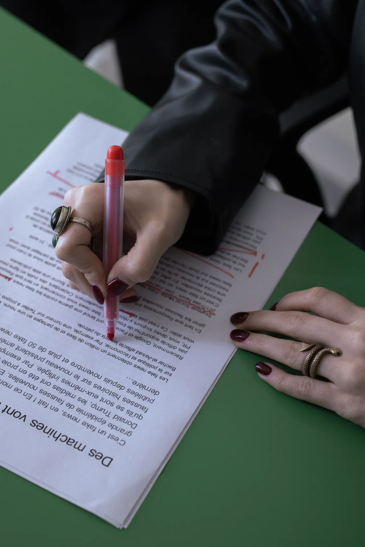 Main corrigeant un texte imprimé au stylo rouge